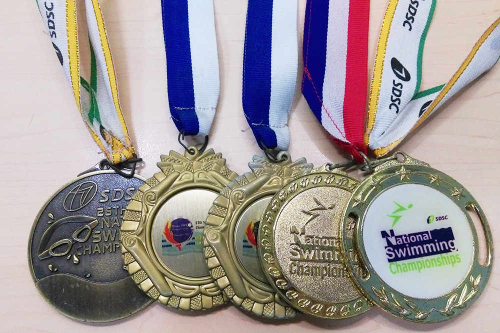 Hua Han’s swimming medals, a testament to his go-getter spirit.
