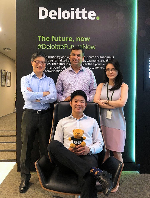 Leong Hui (sitting) receiving the Deloitte bear for his great performance during his internship