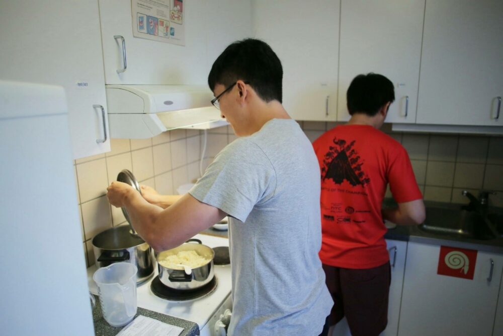 Shane (left) cooked chicken rice while Xavier (in red) prepared the ingredients.