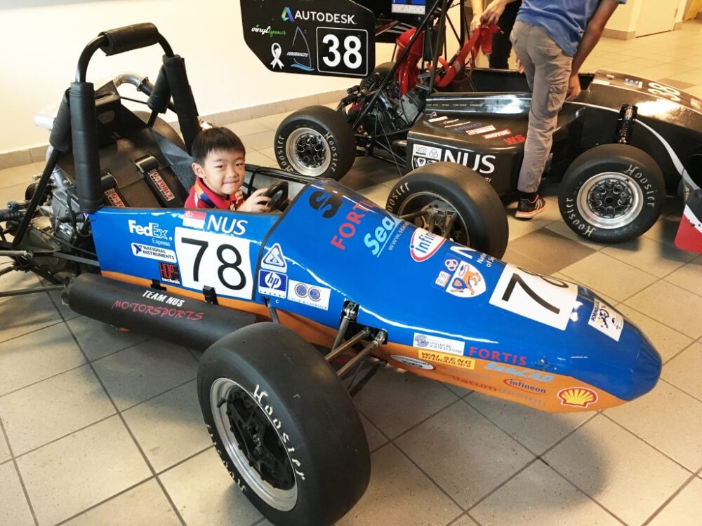 Eugene and Emily’s son taking a “spin” with an F1 car at the NUS Faculty of Engineering
