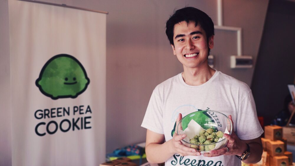 Ying Quan proudly sharing the Green Pea Cookie at a local farmers’ market, a snack sold by Peasures Inc.