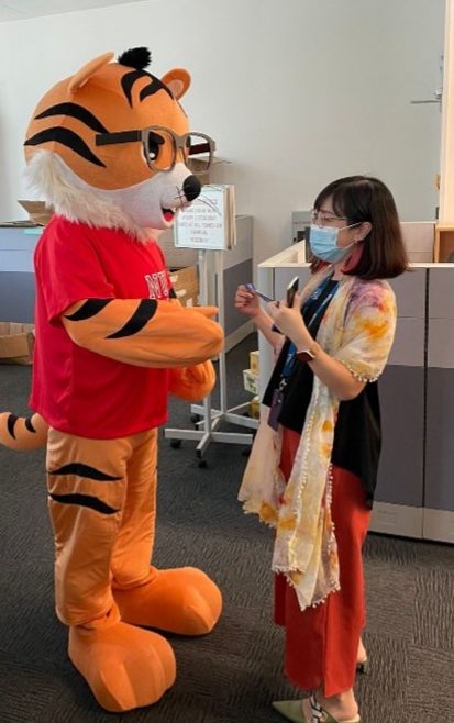 Tycoon handing out a lanyard to an MSc Programmes Office staff member