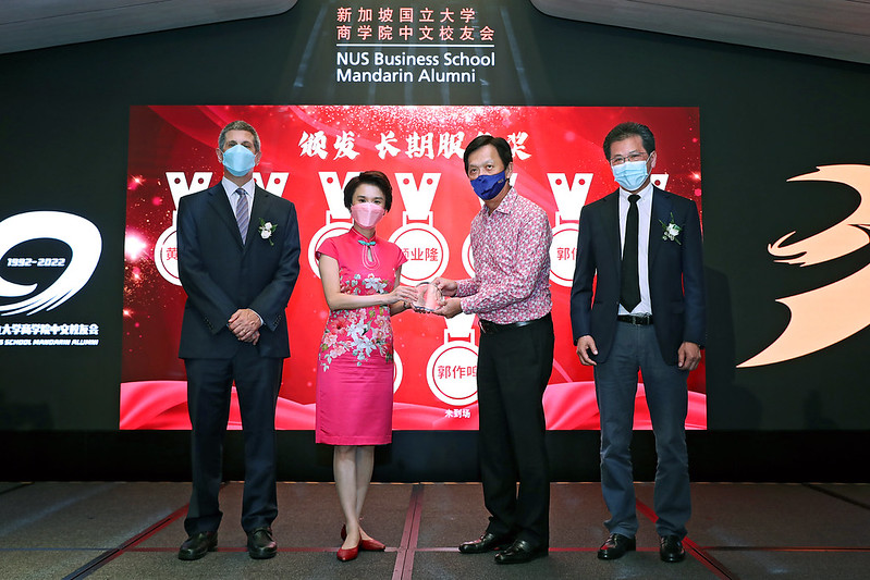 Guest-of-Honour Ms Low Yen Ling (2nd from left) giving out the Long Service Award to Mr Robin Ng (3rd from left), Founding President of the Mandarin Alumni Association. Together with them are Distinguished Professor Andrew Rose (far left), Dean of NUS Business School and Mr Jason Yeo (far right), current President of the Mandarin Alumni Association. 