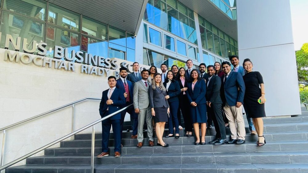 Freshmen from the 2022 MBA cohort posing for a group photo in front of the Business School