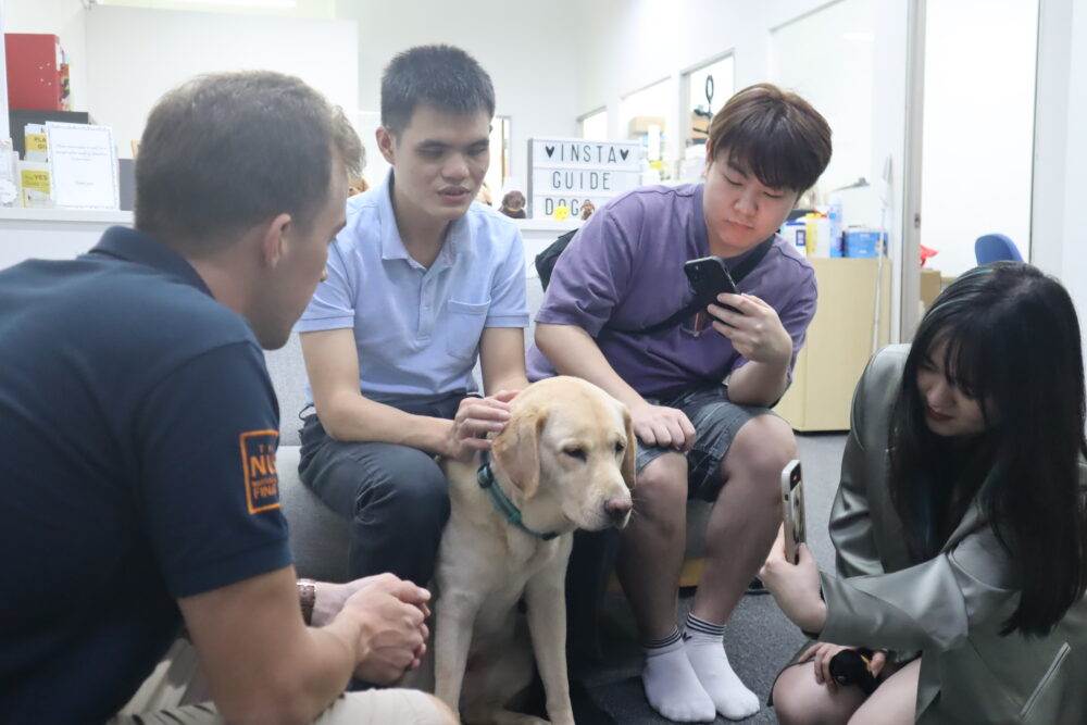 Hong Seng (second from left) introducing his guide dog, Clare, to Kilian (extreme left), Lex (second from right), and Meiwen (extreme right).
