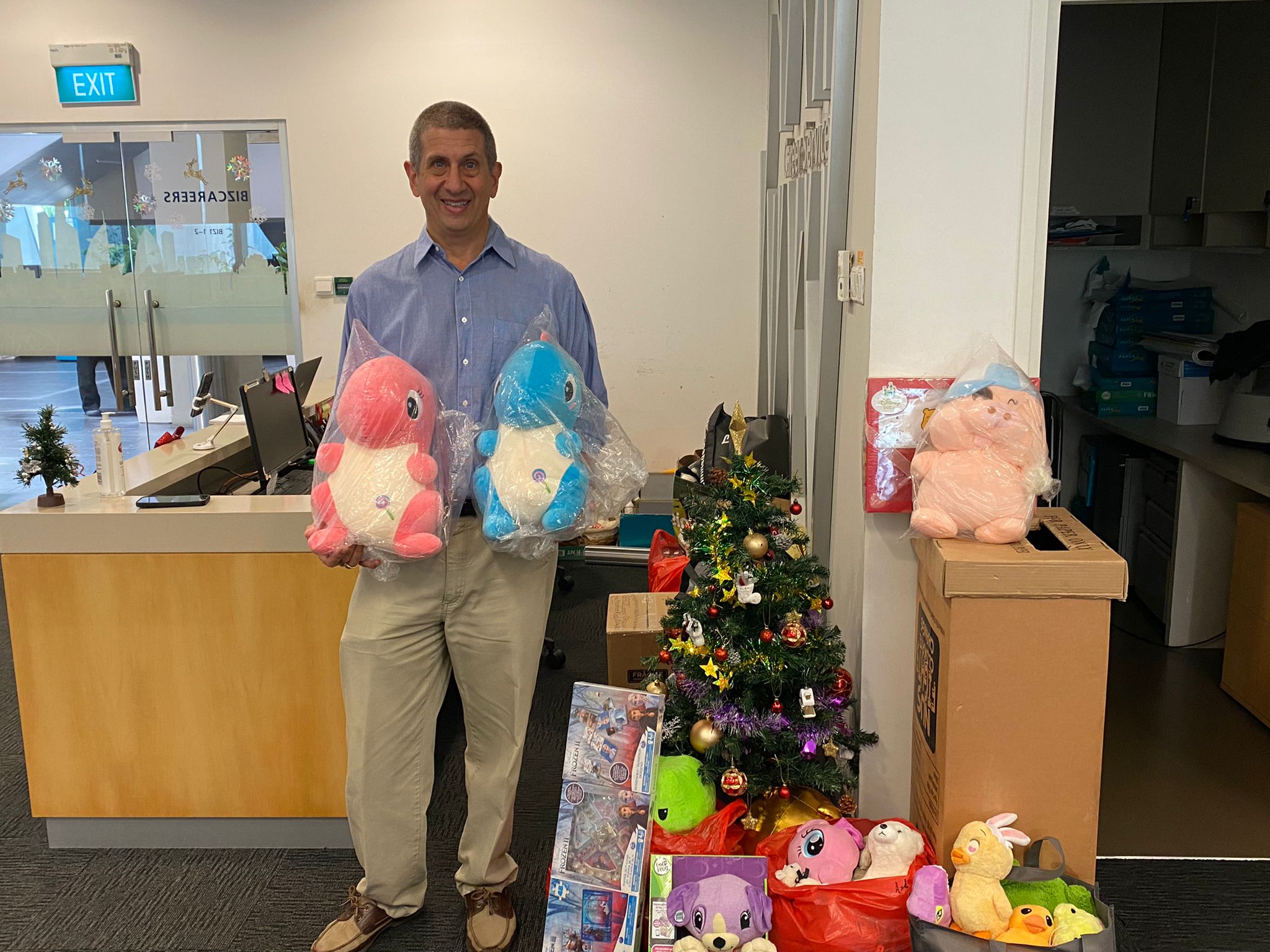 Dean Andrew Rose with the collection of pre-loved toys in the BIZCareers Office