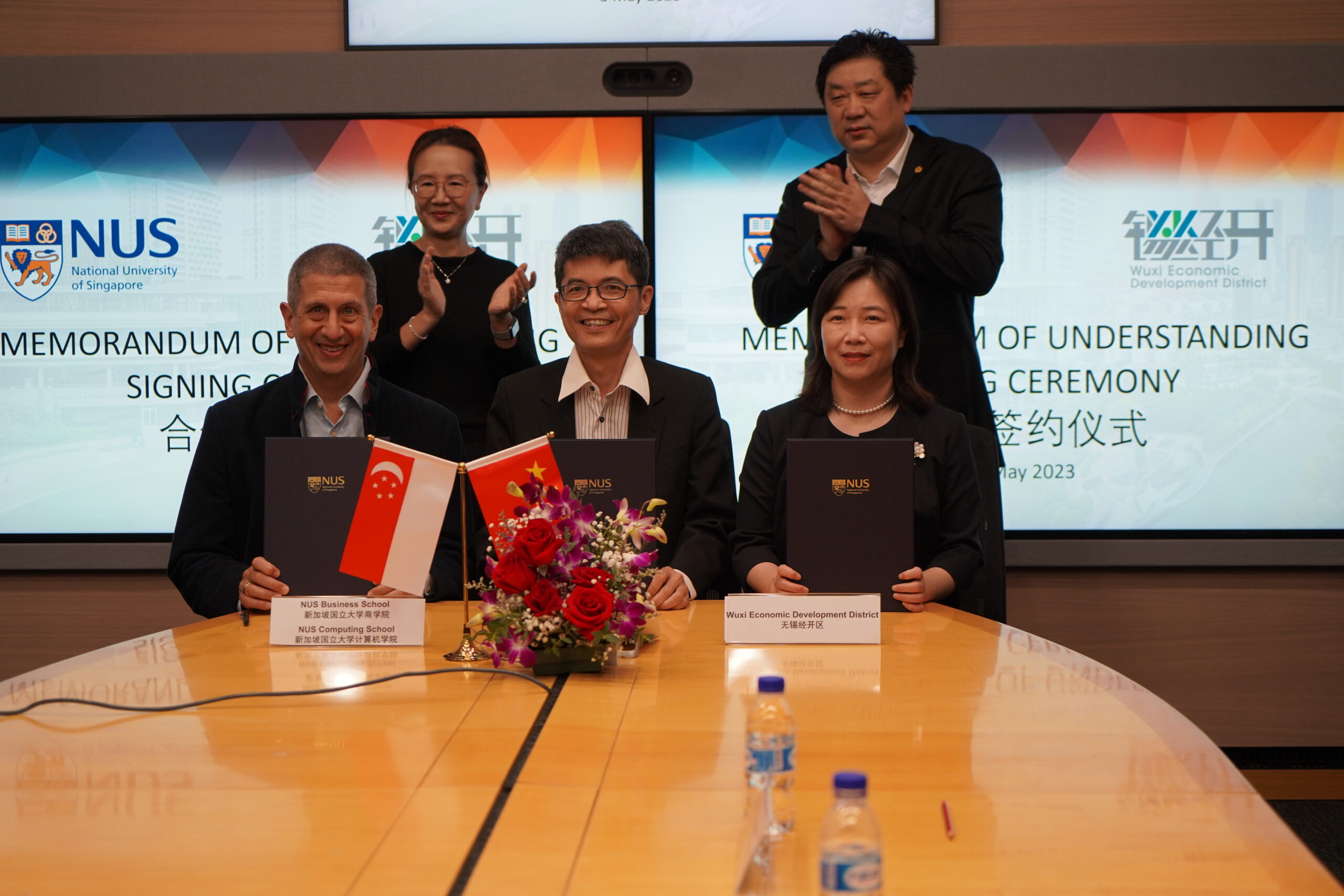 (Front row from left) Prof Andrew Rose, Dean of NUS Business School, Prof Tan Kian Lee, Dean of NUS School of Computing and Ms Yan Qin, Deputy Director of the Management Committee in Wuxi Economic Development Zone signed the MOU, witnessed by Prof Susanna Leong (back row left) and Mr Zhao Jianjun. 